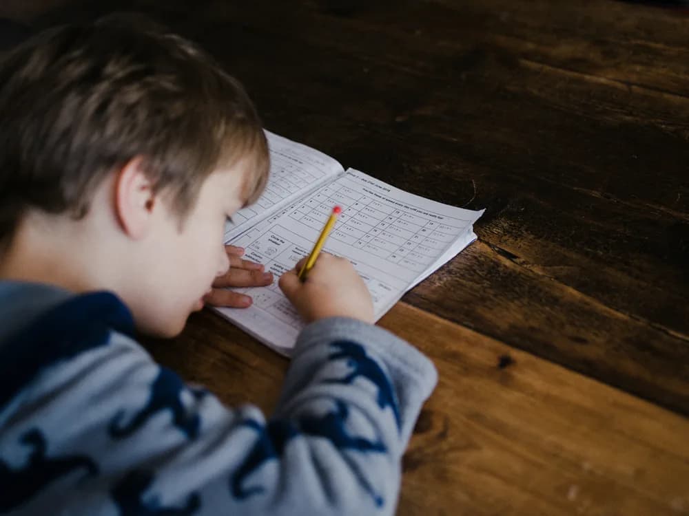Student writing study notes at a desk